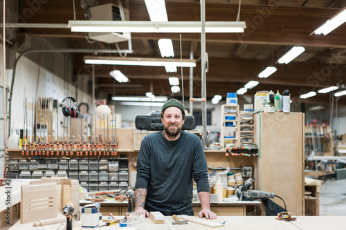 Portrait of smiling carpenter standing in workshop photo