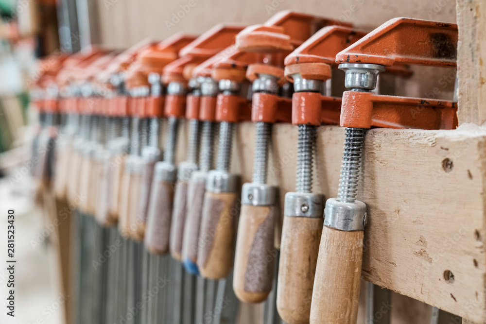 Close up bar clamps on wooden plank in workshop Close up bar clamps on wooden plank in workshop