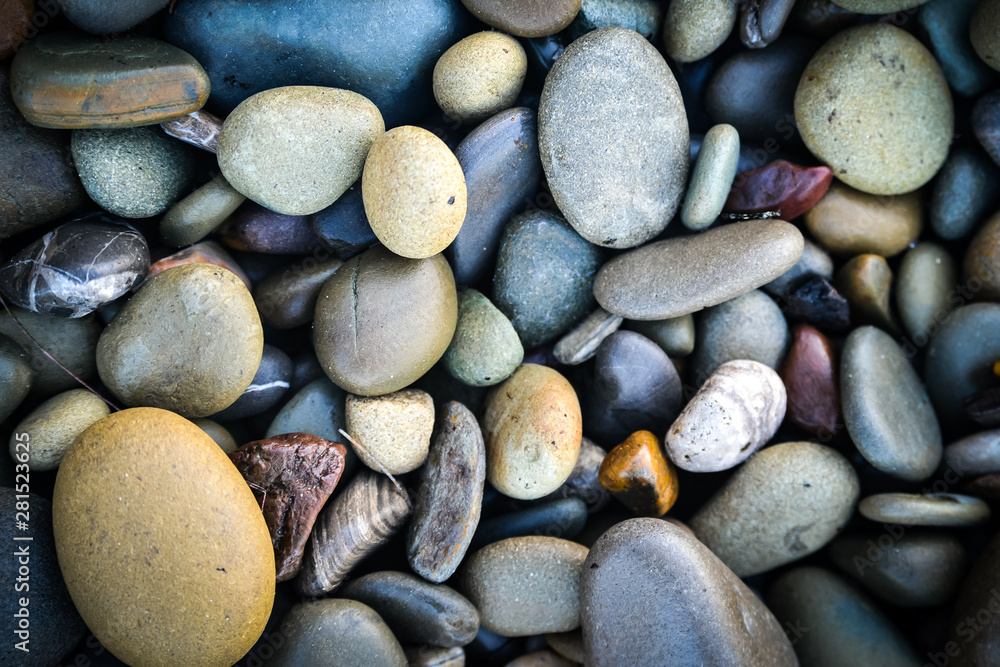 Pebbles on the beach in different colors, cold mood, blues and yellows Pebbles on the beach in different colors, cold mood, blues and yellows