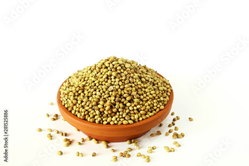 coriander seeds in bowl on white background top view