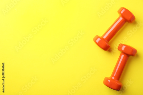Bright dumbbells and space for text on color background, flat lay. Home fitness © New Africa