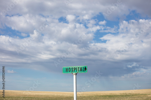 Rural hospital sign against cloudy sky