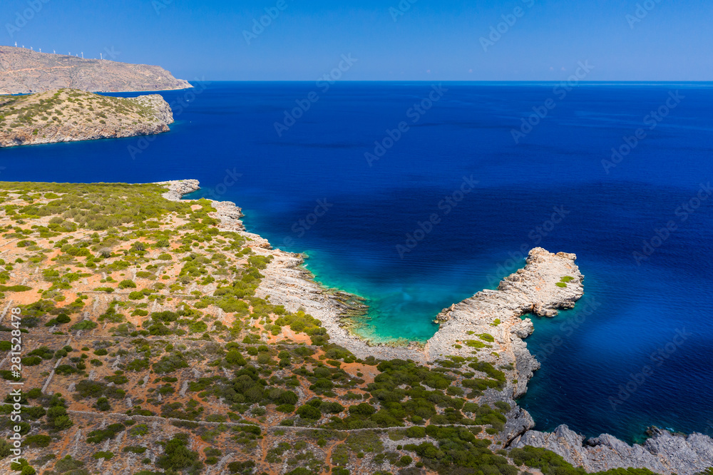 Aerial drone view of the dry, yellow coastline of the Greek island of Crete in the middle of summer