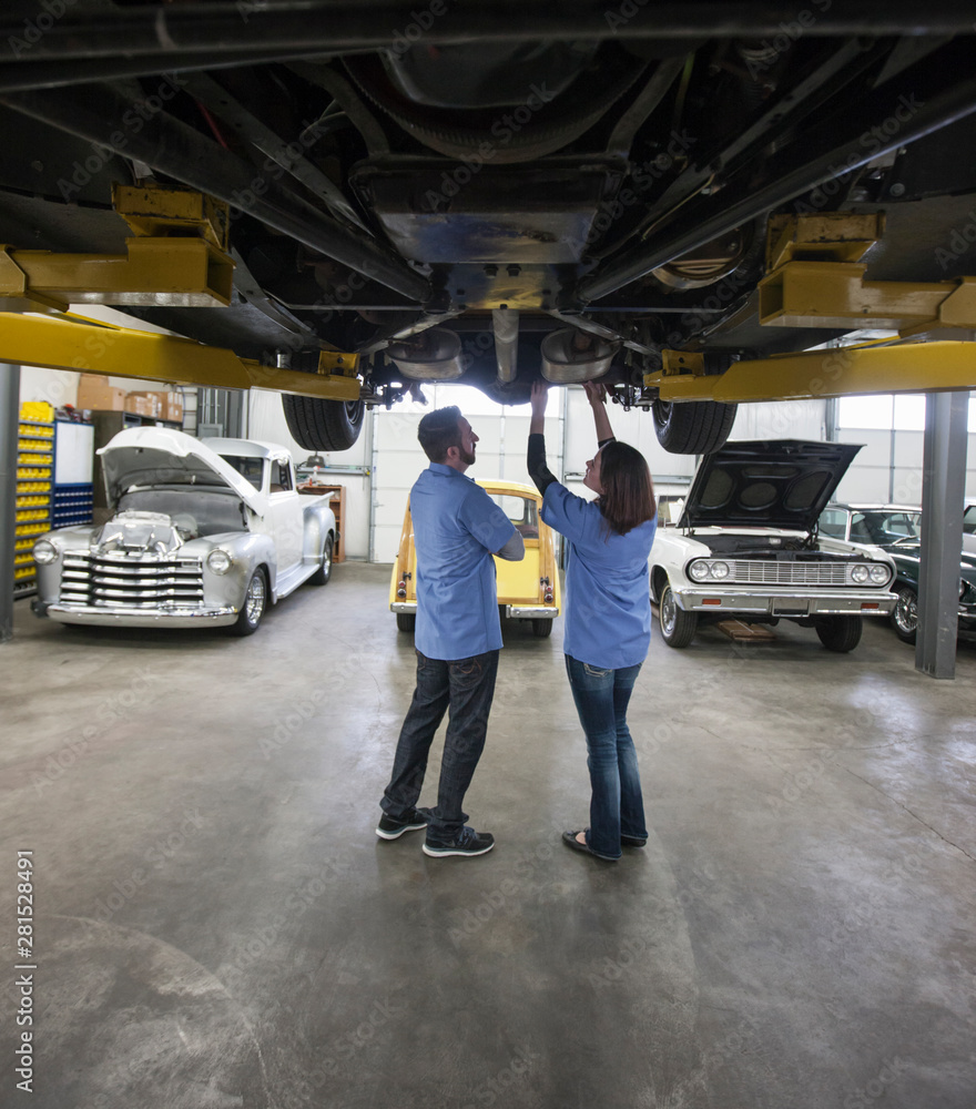 Mechanics examining car in automobile repair shop Mechanics examining car in automobile repair shop