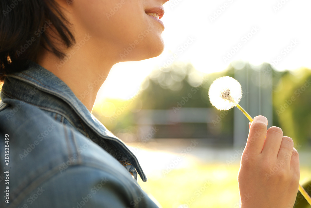 Young woman with dandelion in park on sunny day, closeup. Allergy free concept Young woman with dandelion in park on sunny day, closeup. Allergy free concept
