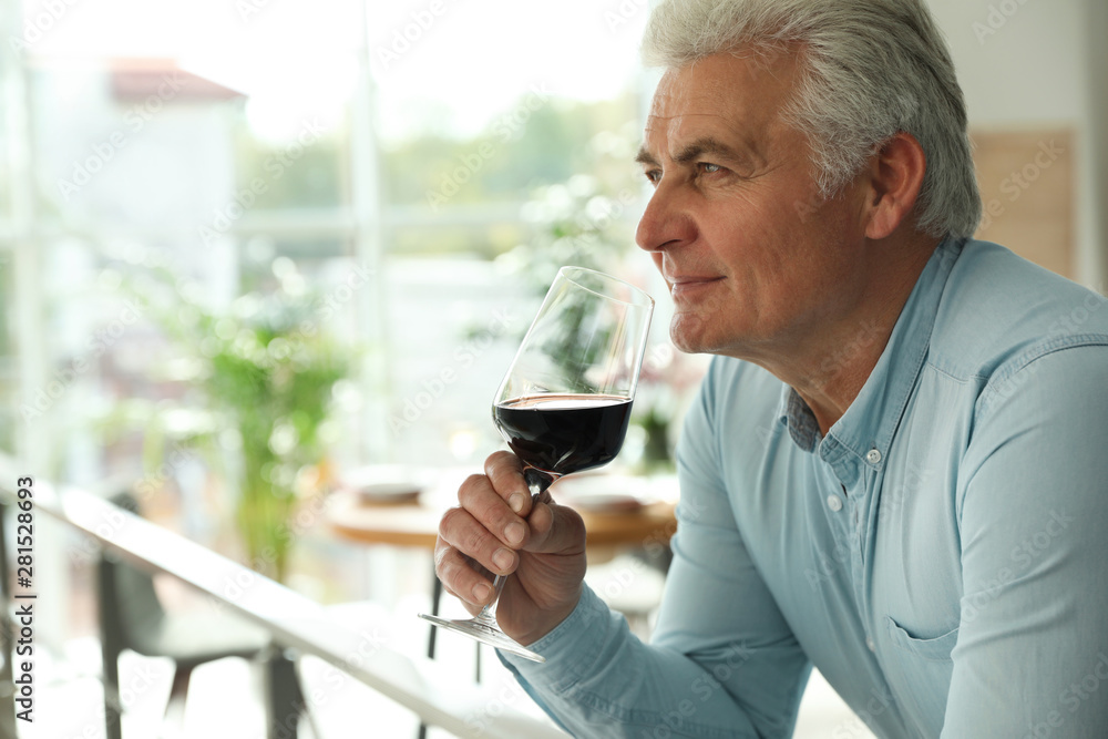 Senior man with glass of wine in restaurant. Space for text Senior man with glass of wine in restaurant. Space for text