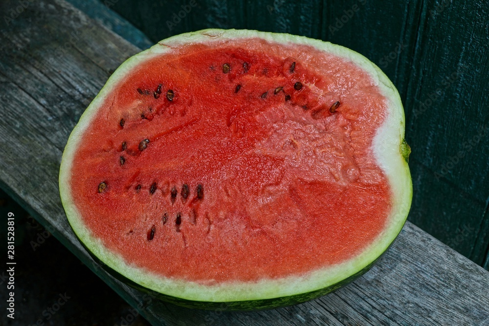 a large piece of red ripe watermelon lies on a gray table board