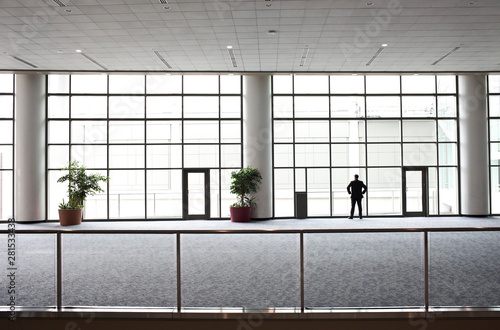 Rear view of businessman looking through window in convention center