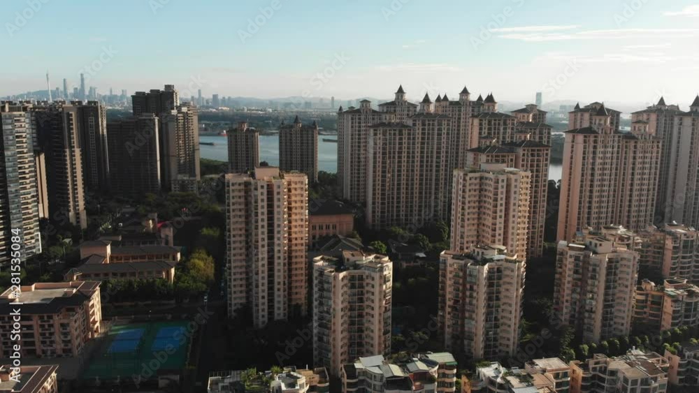 In the morning light we see a large number of multi-storey residential buildings along the river. Developed infrastructure, sports grounds, parking, green streets. Guangzhou, China In the morning light we see a large number of multi-storey residential buildings along the river. Developed infrastructure, sports grounds, parking, green streets. Guangzhou, China