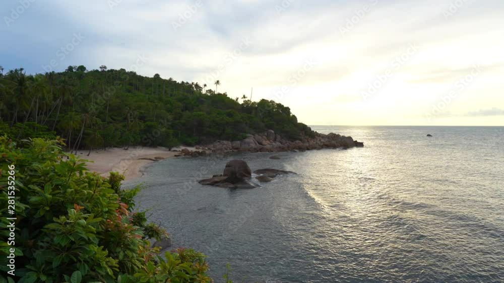 Sunsets on the ocean tide as it rolls in over huge rocks to the white sandy beach. Sunsets on the ocean tide as it rolls in over huge rocks to the white sandy beach.