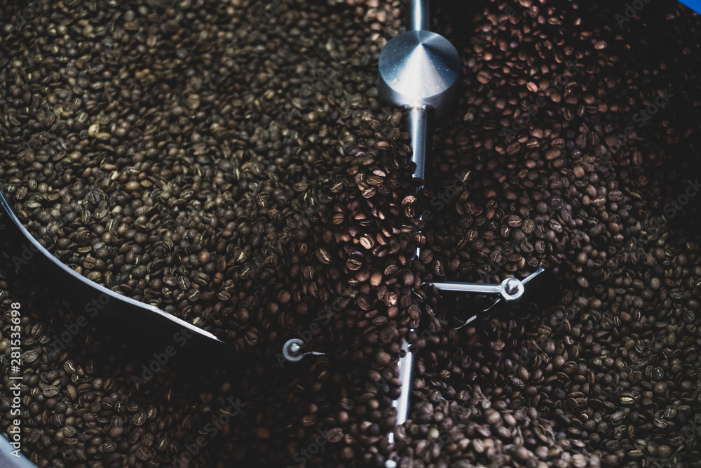 Close up of freshly roasted coffee beans in coffee roaster Close up of freshly roasted coffee beans in coffee roaster