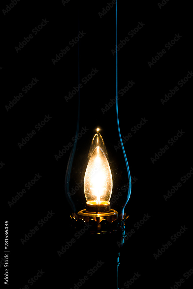 old lantern lit up in a dark room