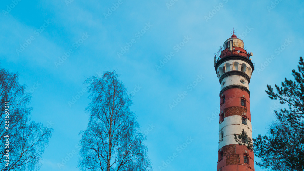 Naklejka premium Lighthouse in the forest among the trees. red and white lighthouse
