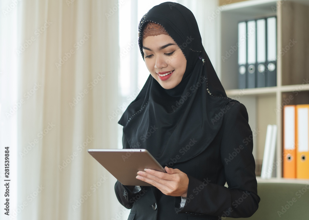 Modern young muslim woman using touchpad and checking order. Modern young muslim woman using touchpad and checking order.