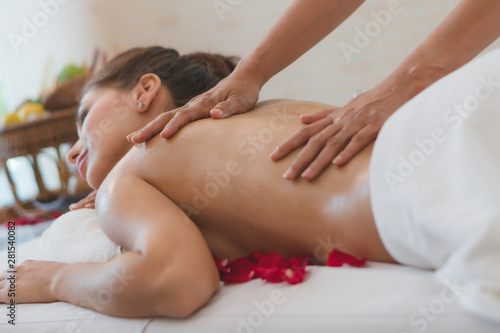 Beautiful woman lying down on the bed relax in spa salon with oil massage.