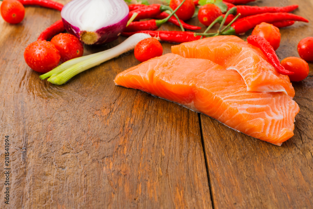 Raw salmon fillets and ingredients for cooking on old wooden floors