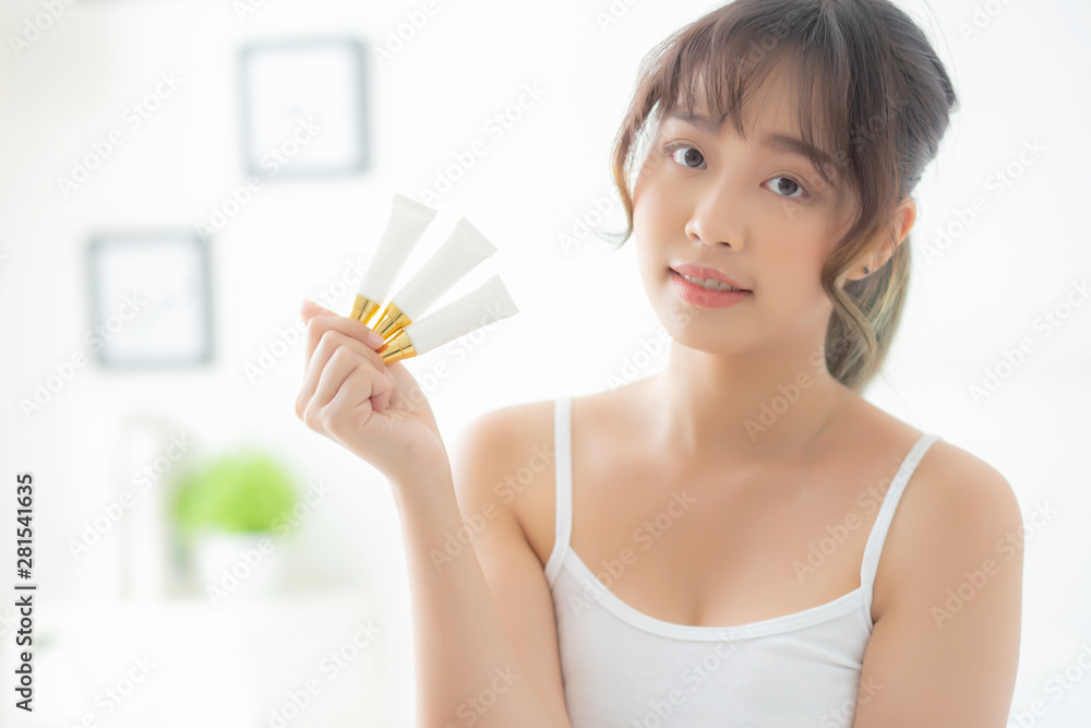 Beautiful portrait young asian woman holding and presenting cream or lotion product, beauty asia girl show cosmetic makeup and moisturizing for skin care, healthy care and wellness concept. Beautiful portrait young asian woman holding and presenting cream or lotion product, beauty asia girl show cosmetic makeup and moisturizing for skin care, healthy care and wellness concept.