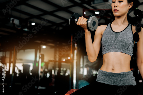 sport woman at fitness gym club doing exercise for arms with dumbbells and showing muscle bodybuilding, fitness concept, sport concept