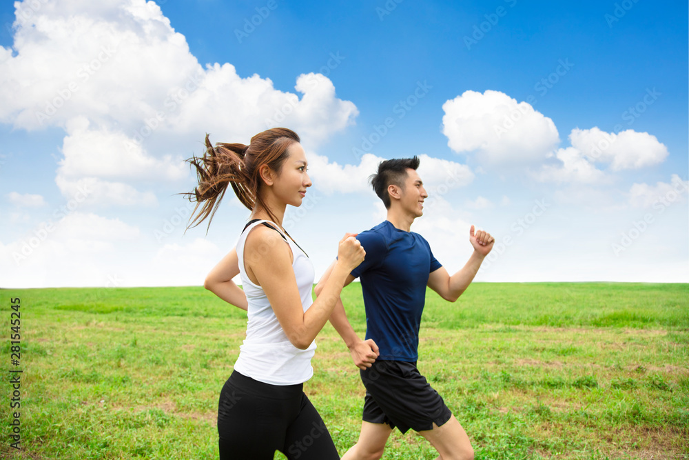 happy young Couple jogging and running on the grass happy young Couple jogging and running on the grass