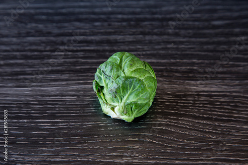 Rustic, organic, healthy brussel sprouts. Home grown and displayed on a dark wood grain bench. Dark green leafy outer, white and creamy inside. Brassica high in vitamins C, B and K, good for winter. photo