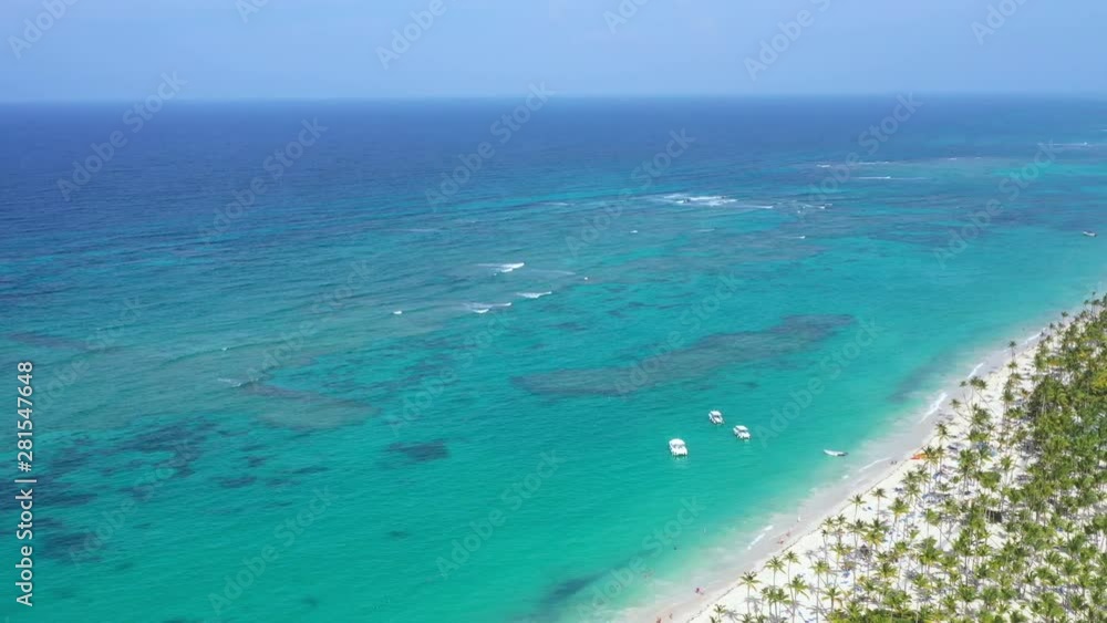 Aerial view from drone on seashore with resorts. Tropical destination for travel and summer vacations. People faving fun on beach with palm trees and sunbeds Aerial view from drone on seashore with resorts. Tropical destination for travel and summer vacations. People faving fun on beach with palm trees and sunbeds