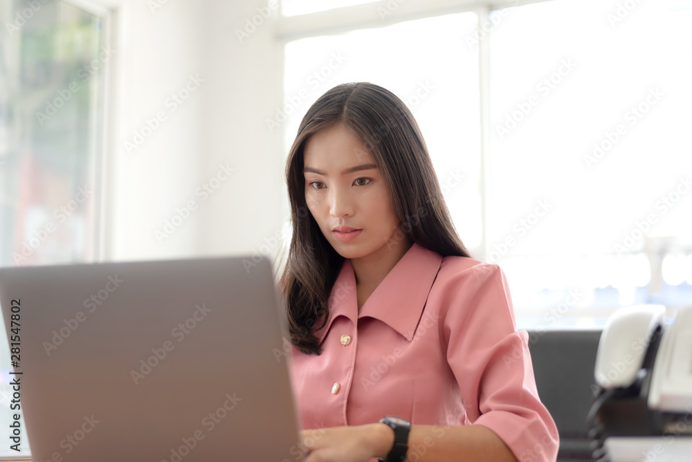 Young asian businesswoman checking the time, work with laptop computer. Young asian businesswoman checking the time, work with laptop computer.