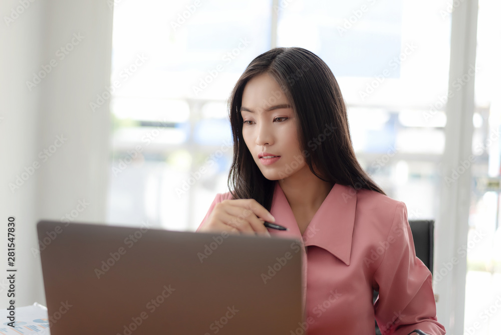 Young asian businesswoman checking the time, work with laptop computer. Young asian businesswoman checking the time, work with laptop computer.