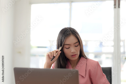 Young asian businesswoman checking the time, work with laptop computer.