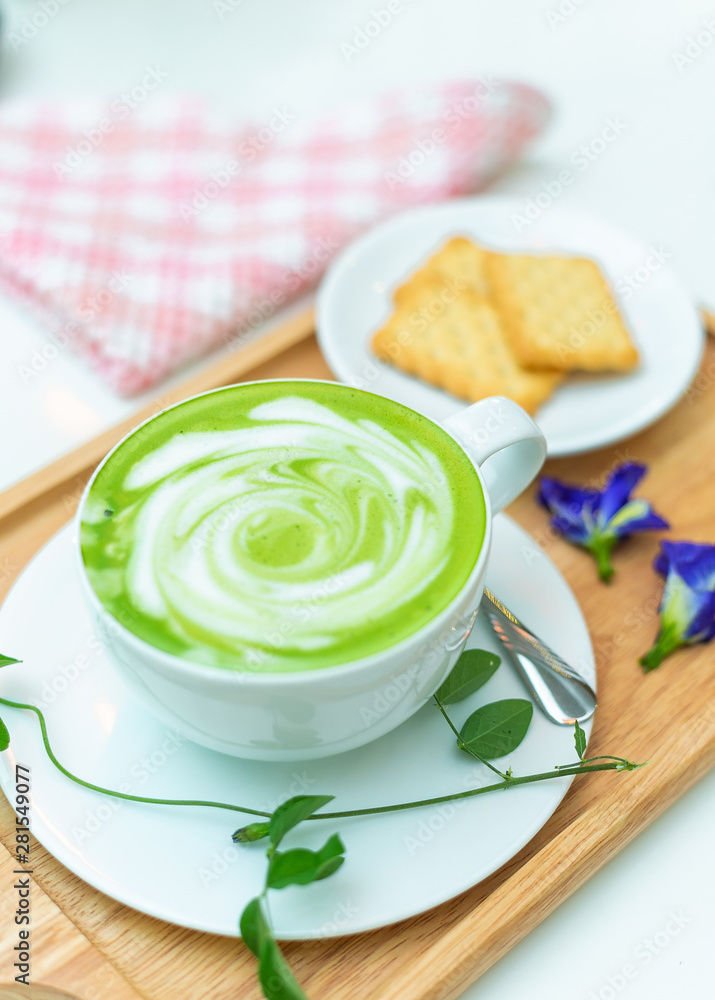 Hot green tea milk with cracker and spoon. Hot green tea milk with cracker and spoon.