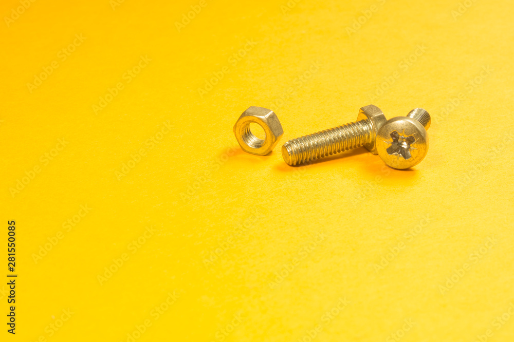Steel screw on a yellow background Steel screw on a yellow background