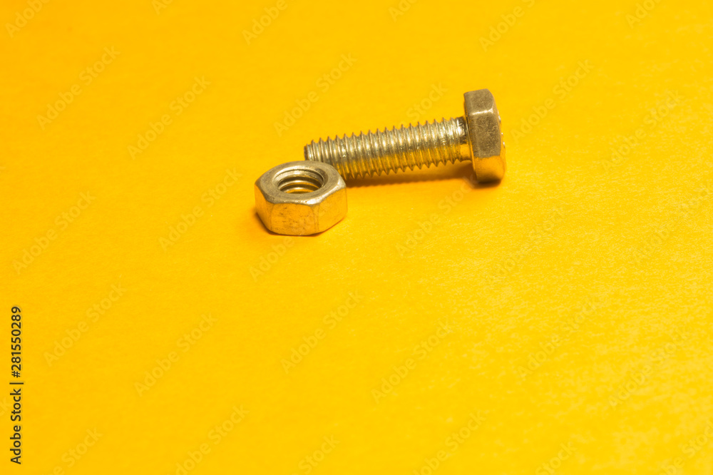 Steel screw on a yellow background Steel screw on a yellow background