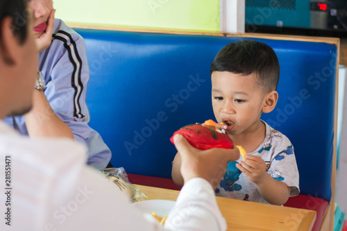 child with his parents eating cake