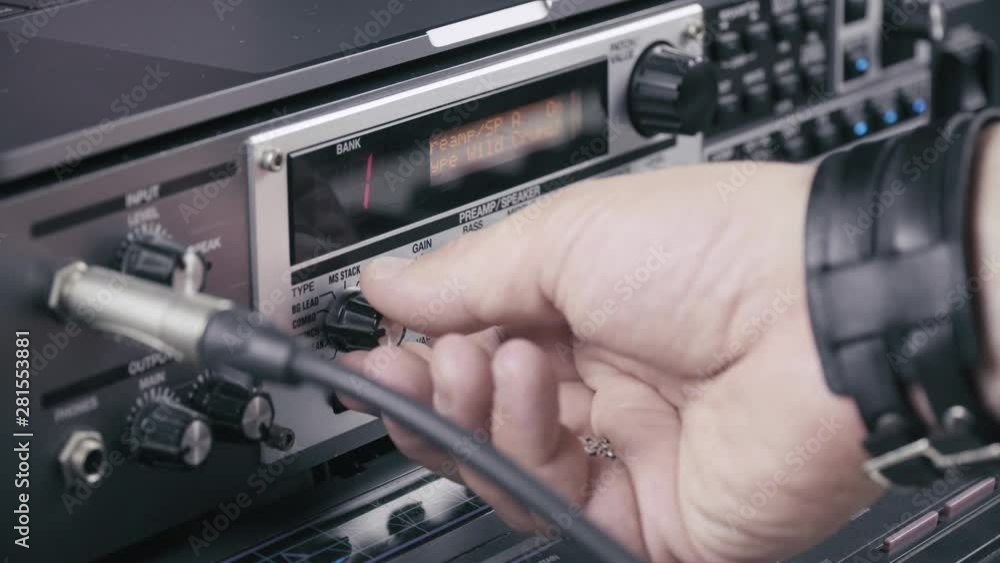 Musician sets up the levels of a guitar multi effect multi effect, close up 4K