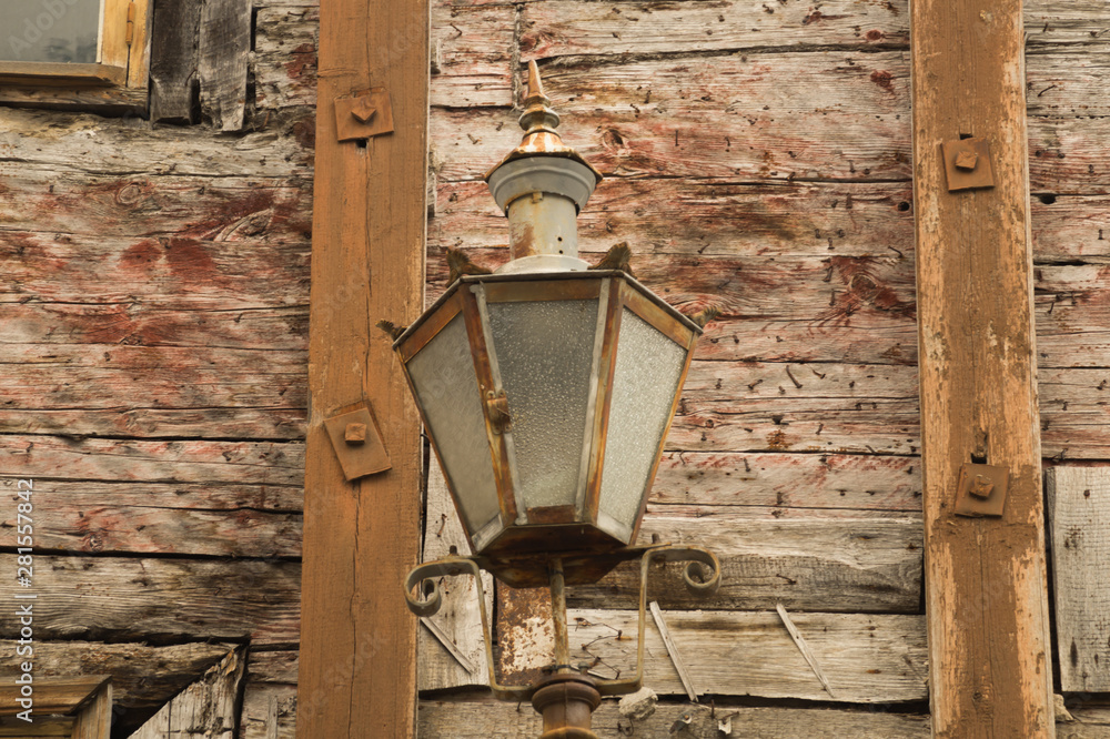 Windows of the old wooden house. wooden wall with vintage lamp