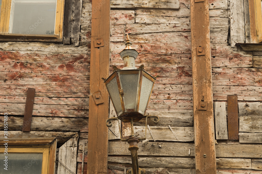 Wooden wall of old wooden house with vintage lamp