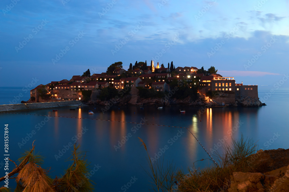 sveti stefan village hotel flying between sky and sea. Glows with lights from windows in the night
