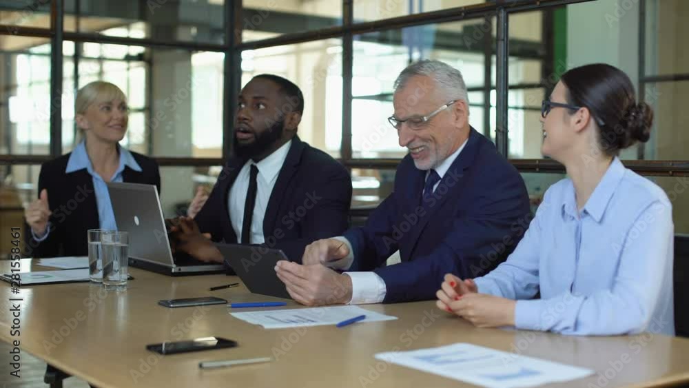 Excited business team celebrating work achievement checking sales results tablet Excited business team celebrating work achievement checking sales results tablet