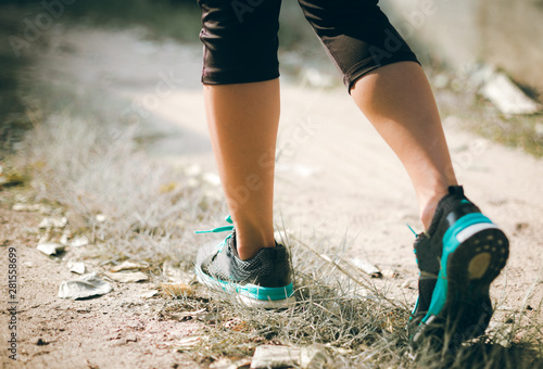 Runner feet running on road closeup on shoe. woman fitness jog workout concept