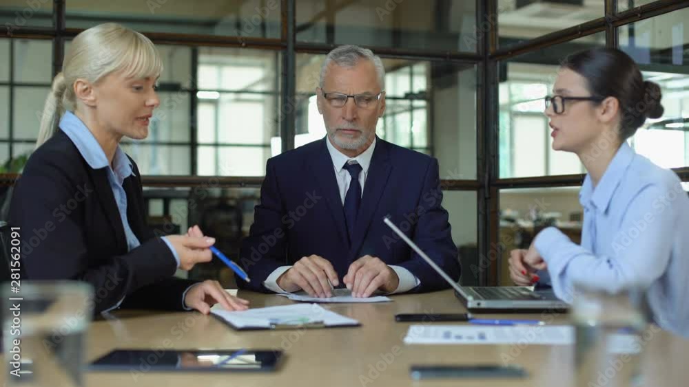 Mature man meditating in office tired of shouting colleagues, reducing stress Mature man meditating in office tired of shouting colleagues, reducing stress