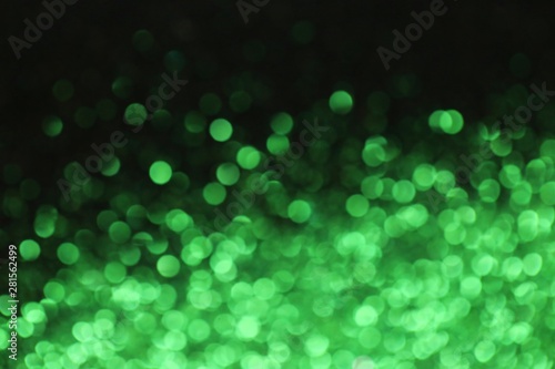 Green abstract background with bokeh defocused lights. Phone wallpaper. green shining bokeh on black background.Christmas, New Year background.