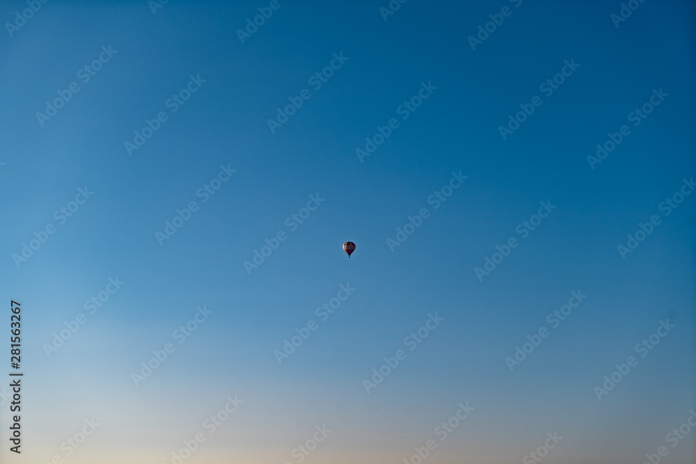Hot air balloon high in the bright blue sky Hot air balloon high in the bright blue sky