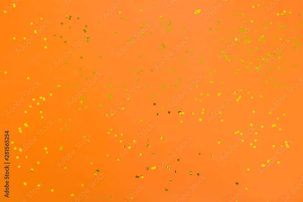 Orange halloween background with golden confetti. Festive surface. Flat