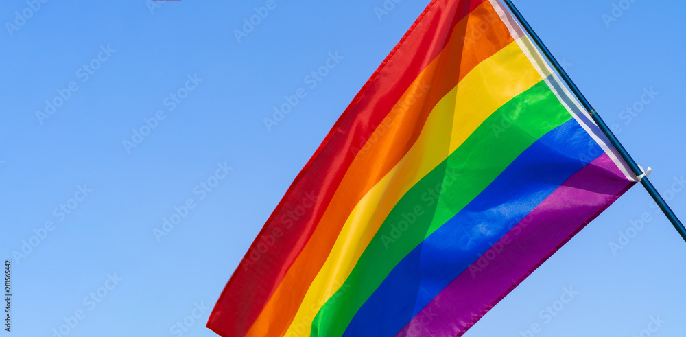 LGBT waving flag in the sky on flagpole