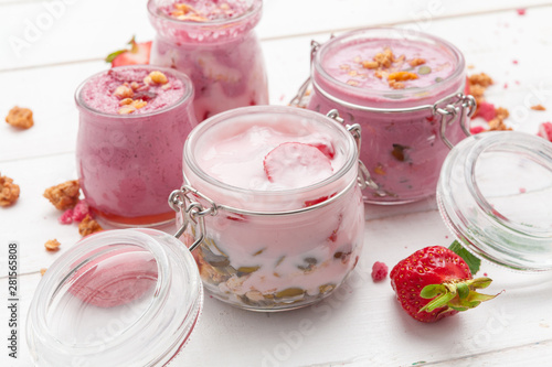 Strawberry with yogurt on white rustic wooden background. Cream dessert