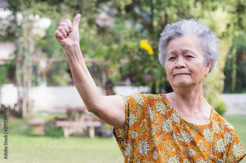 Senior woman standing smiling and thumbs up gesture