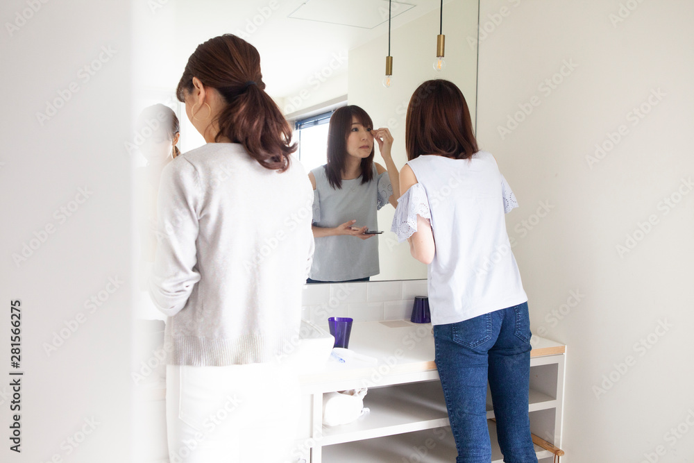 出かける前にメイクをする女性達 出かける前にメイクをする女性達