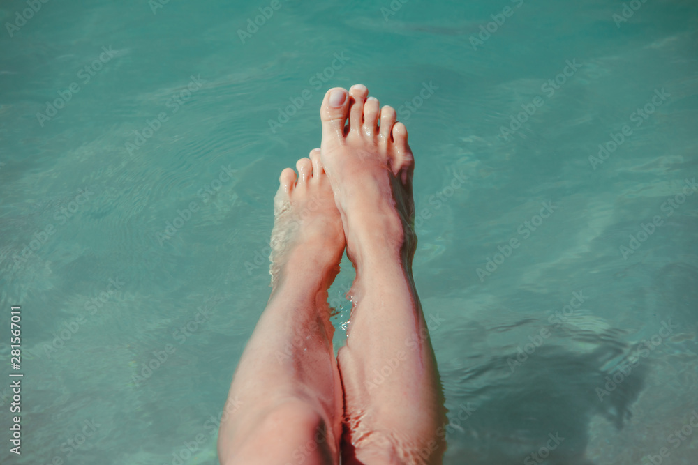 view of woman legs blue sea water on background view of woman legs blue sea water on background