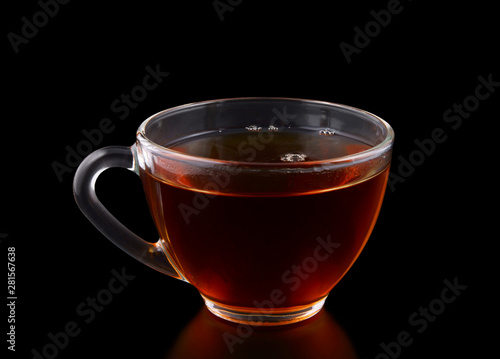 Glass cup of tea on black background