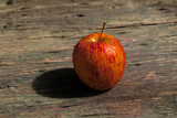 red  withered Apple on a wooden table.