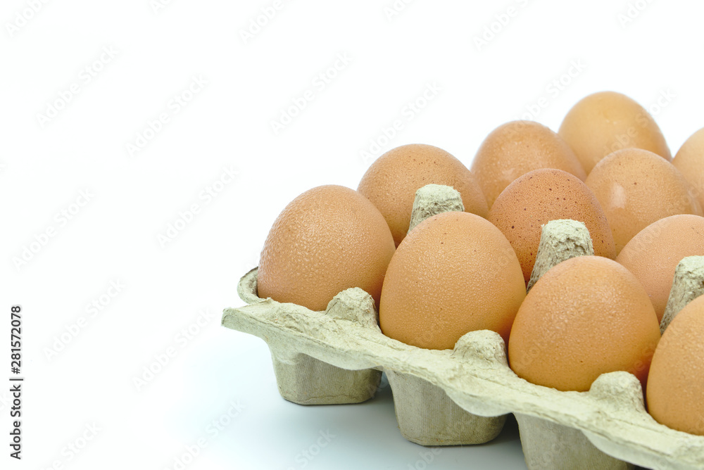 Isolated dozen of chicken eggs in brown paper cardboard container on white background with copy space on the left. Isolated dozen of chicken eggs in brown paper cardboard container on white background with copy space on the left.